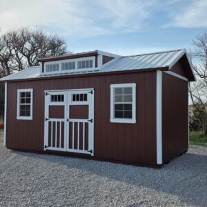Exterior of an upscale shed, featuring two windows and double doors on the front.