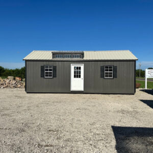 Exterior of dark grey garage with white door.