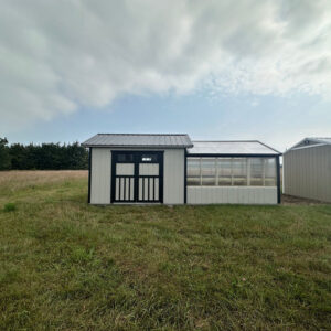 Exterior of a large shed connected to a greenhouse.
