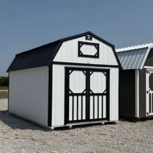 Exterior of a small, barn-styled shed featuring double doors on the front and a small window/vent plate