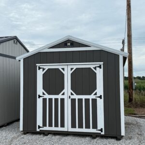 Exterior of dark grey garden shed with white accents.