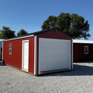 Exterior of red and white garage showcasing the garage door and white side door.