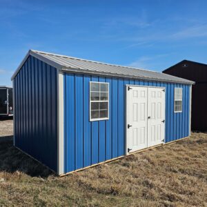 Exterior view of a long shed with a set of double doors and two windows.