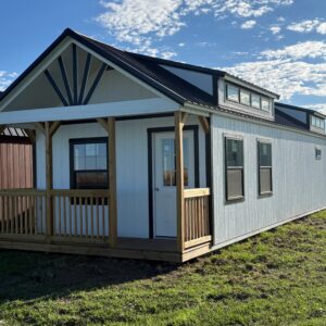 Exterior view of a large, white cabin with a front porch.